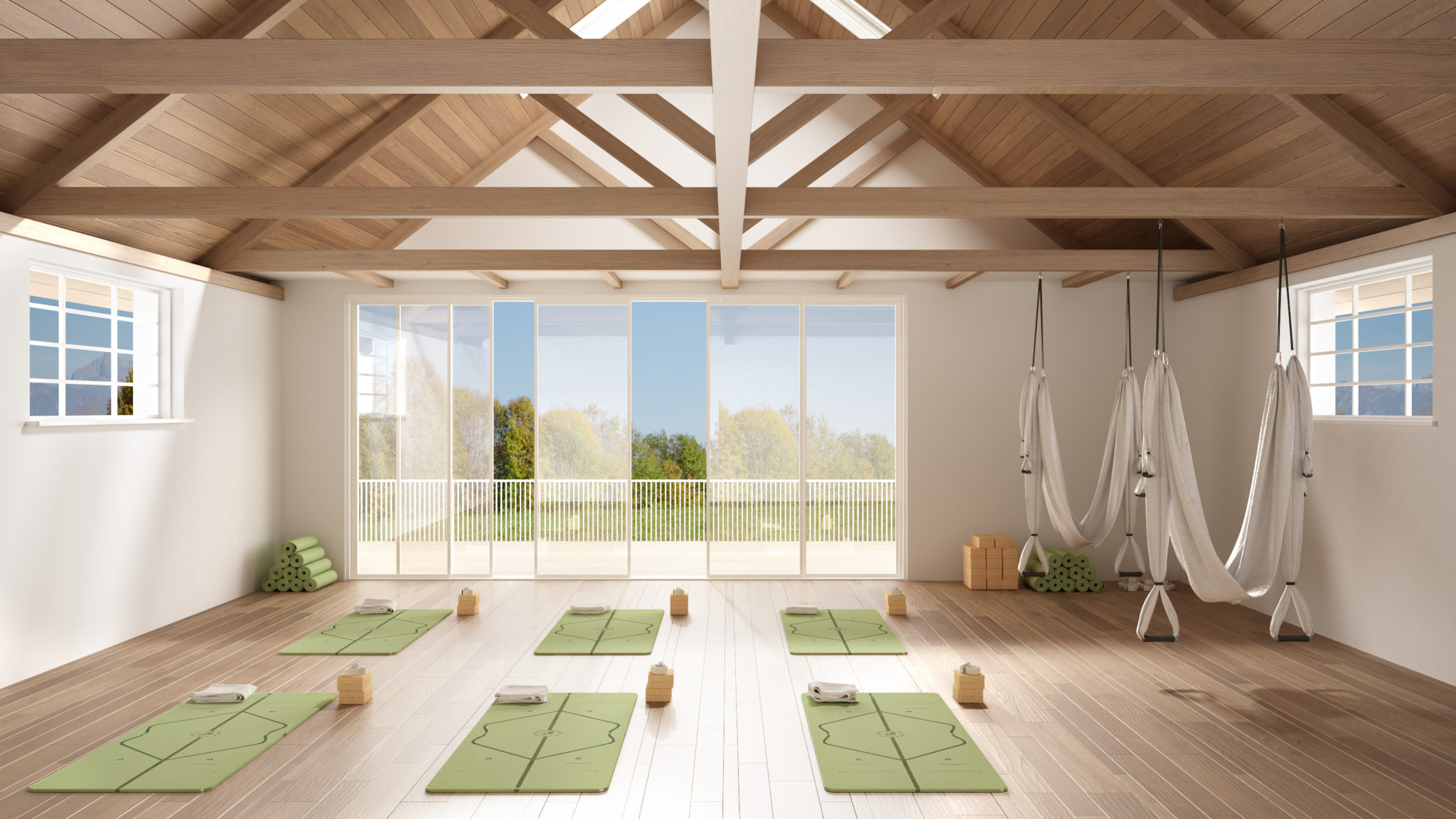 yoga instructor helping a member with pose during group class in a studio